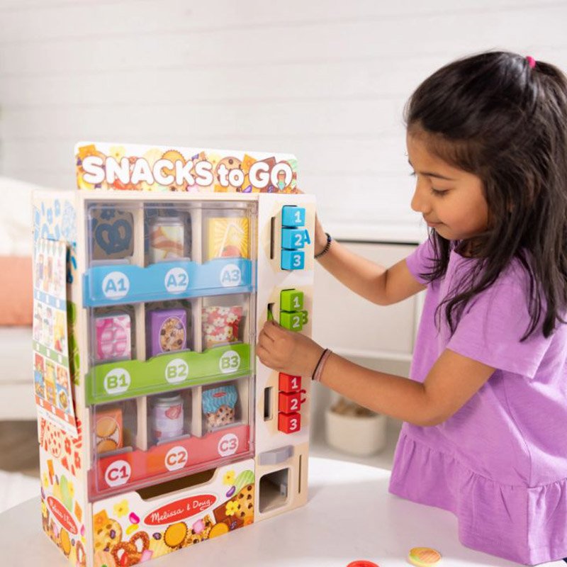 Close-up of play coins and bank card included with vending machine play set