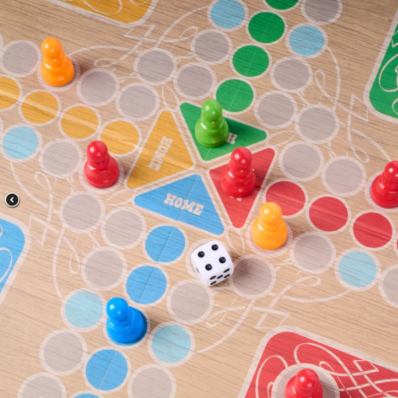 Close-up of dice and 16 coloured pegs from Ludo board game